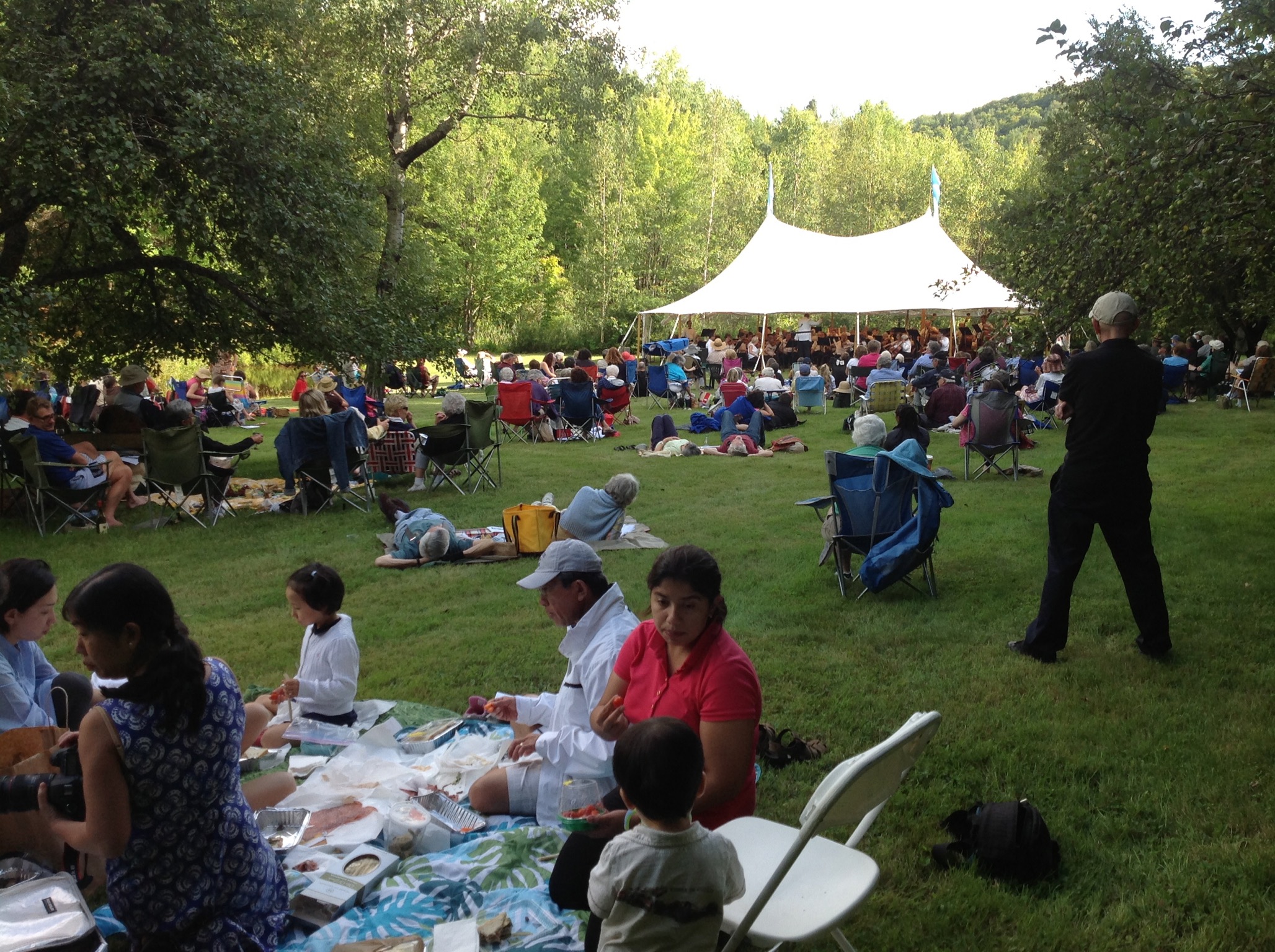 Audience picnicking on the lawn at Moose Meadow in front of the Vermont Philharmonic tent.